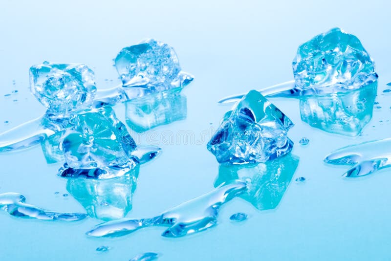 Azure colored ice cubes melted in water on reflection surface ready to be added to a cocktail. Azure colored ice cubes melted in water on reflection surface ready to be added to a cocktail