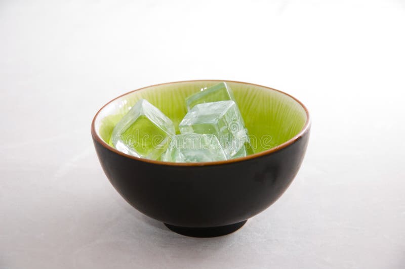 Bowl of ice cubes, in an asian bowl on light background. Bowl of ice cubes, in an asian bowl on light background.