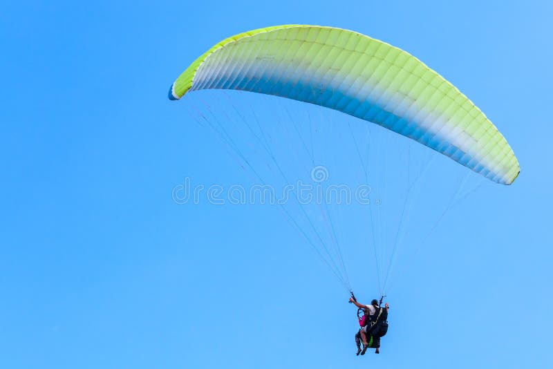 Gleitschirmfliegen im blauen Himmel, im Lehrer und im Anfänger stockfotografie Gleitschirmfliegen im blauen Himmel, im Lehrer und im Anfänger stockfotografie