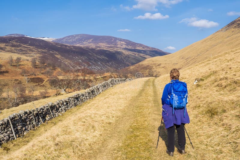 22.03.22 Glen Tilt, Perthshire, Scotland, UK. Female hill walker in blue and purple heading up Glen Tilt. 22.03.22 Glen Tilt, Perthshire, Scotland, UK. Female hill walker in blue and purple heading up Glen Tilt