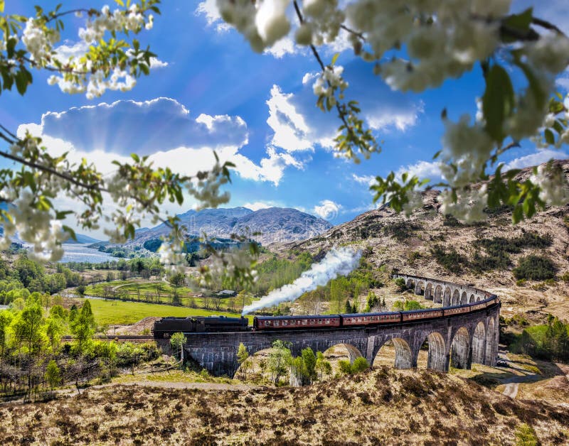 Glenfinnan Railway Viaduct in Scotland with the Jacobite steam train against sunset over lake. Famous Glenfinnan Railway Viaduct in Scotland with the Jacobite stock photo Glenfinnan Railway Viaduct in Scotland with the Jacobite steam train against sunset over lake. Famous Glenfinnan Railway Viaduct in Scotland with the Jacobite stock photo