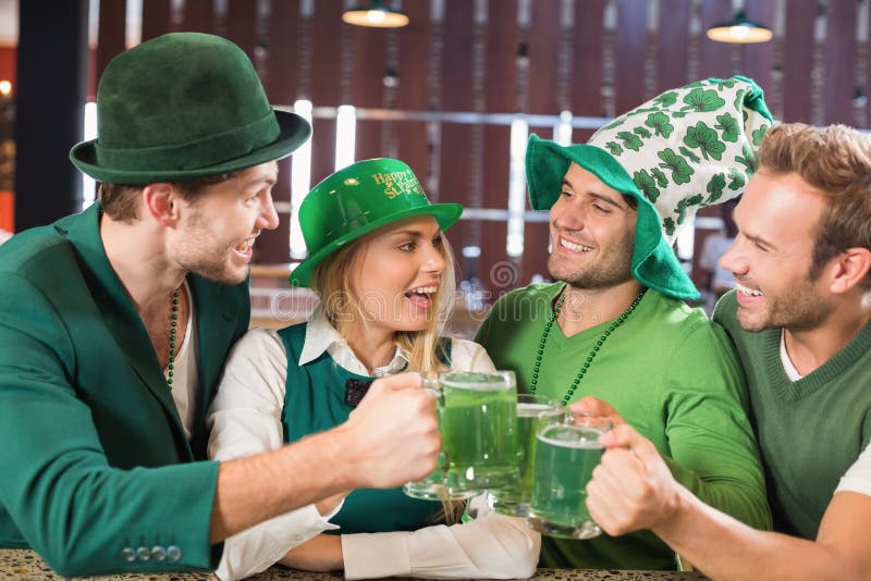 Gli amici che indossano il giorno della st Patricks hanno associato la tostatura dei vestiti immagini stock libere da diritti Gli amici che indossano il giorno della st Patricks hanno associato la tostatura dei vestiti immagini stock libere da diritti