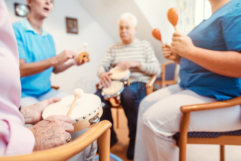 Seniors in nursing home making music with rhythm instruments as musical therapy. Seniors in nursing home making music with rhythm instruments as musical therapy