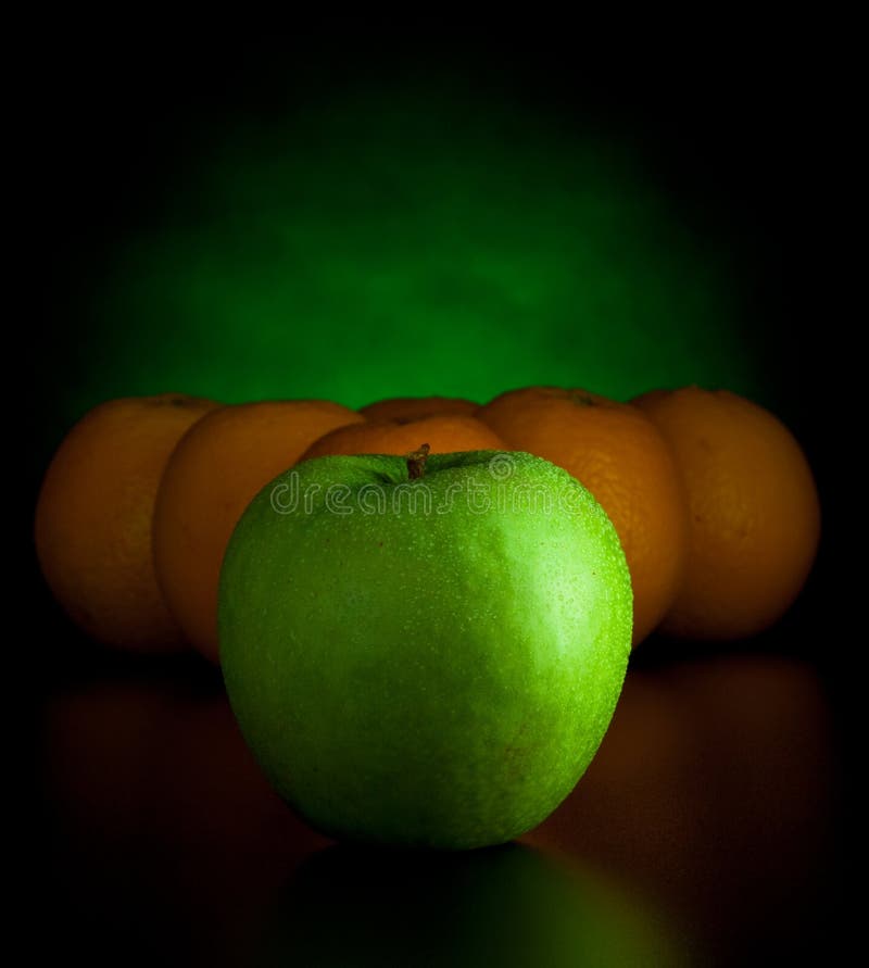 Oranges and apple like billiard balls on black background. Oranges and apple like billiard balls on black background