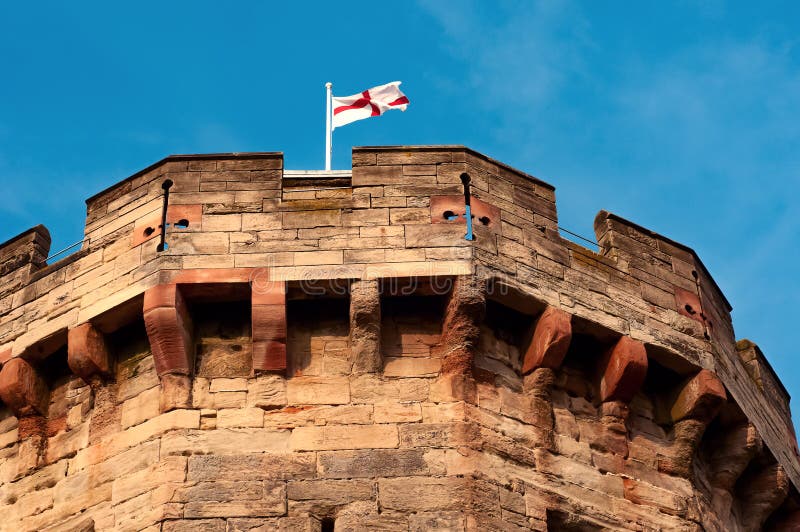 Gli inglesi diminuiscono su una cima del palo della torre medievale del castello fotografie stock libere da diritti Gli inglesi diminuiscono su una cima del palo della torre medievale del castello fotografie stock libere da diritti