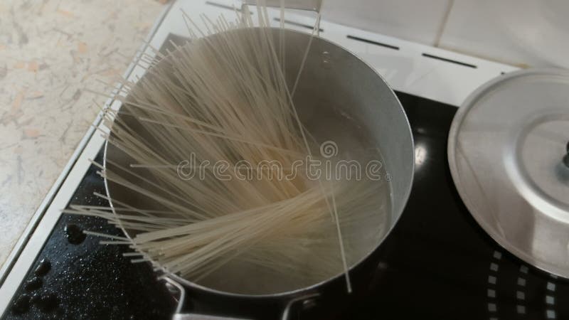 Gli spaghetti del riso sono cucinati in un vaso di acqua bollente sulla stufa Vista superiore