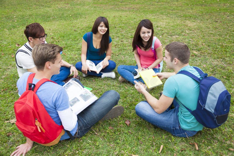 Gli studenti di college che studiano e discutono insieme in città universitaria