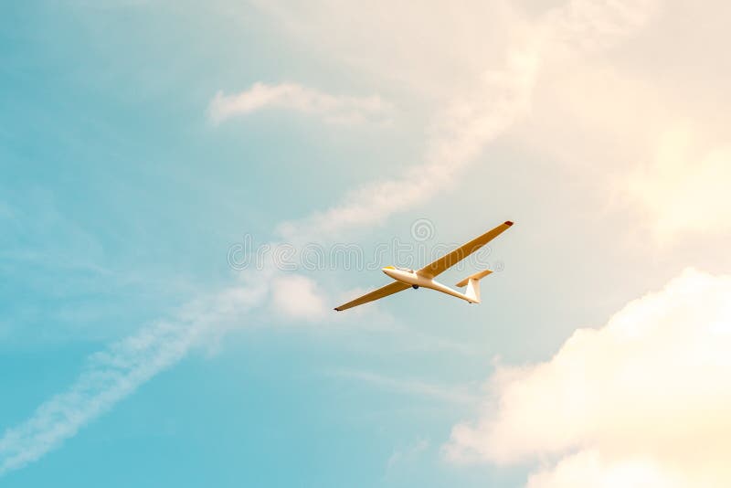 Glider Flying Against the Blue Sky with Clouds and Sunlight Stock Image Image of competition