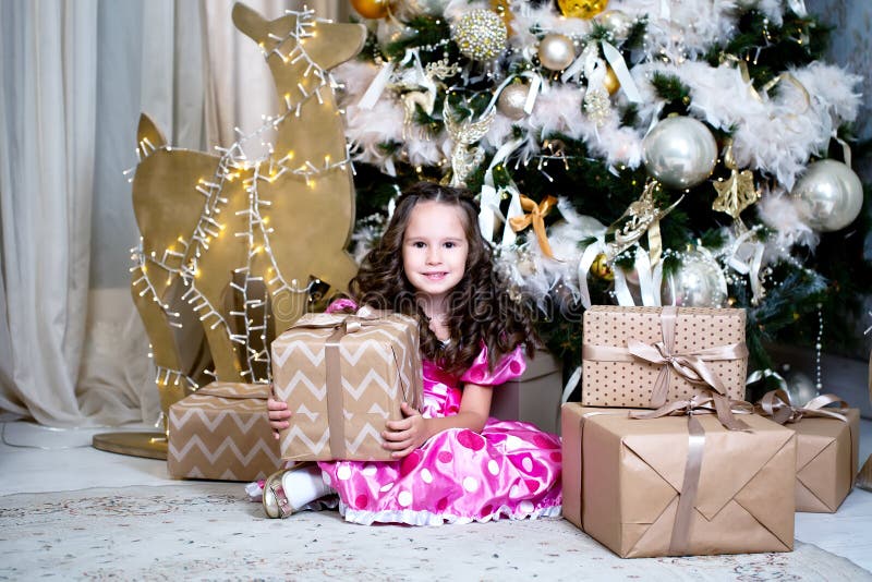 Glimlachend leuk meisje dichtbij dichtbij giften en Kerstboom Nieuwe jaar of Kerstmisviering thuis stock afbeelding Glimlachend leuk meisje dichtbij dichtbij giften en Kerstboom Nieuwe jaar of Kerstmisviering thuis stock afbeelding