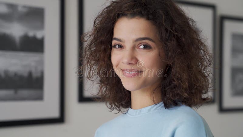 Glimlachend liefdevolle jonge, mooie Latijns-Amerikaanse vrouw die naar camera kijkt.