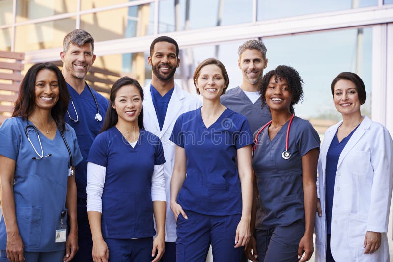 Glimlachend medisch team die zich buiten het ziekenhuis verenigen