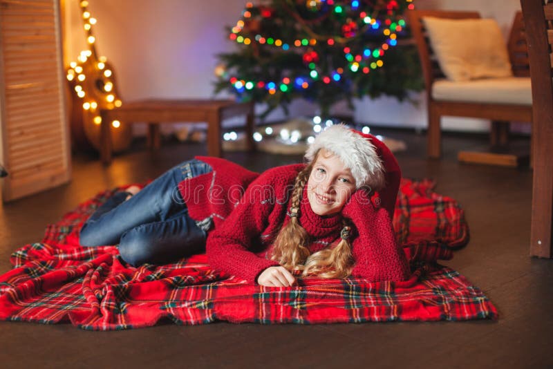 Glimlachend meisje dichtbij Kerstmisboom thuis royalty-vrije stock foto Glimlachend meisje dichtbij Kerstmisboom thuis royalty-vrije stock foto