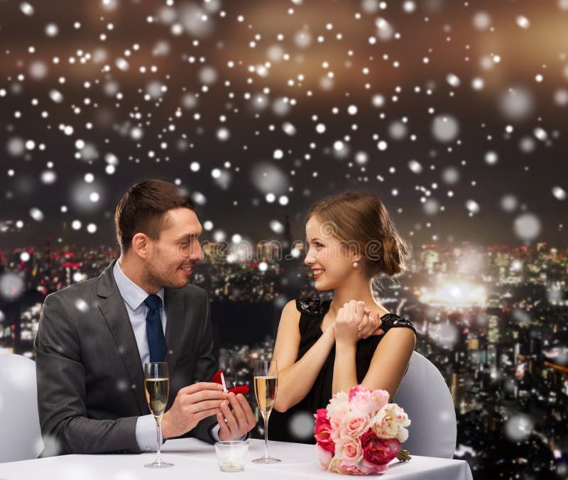 Glimlachend paar met rode giftdoos bij restaurant royalty-vrije stock afbeelding Glimlachend paar met rode giftdoos bij restaurant royalty-vrije stock afbeelding