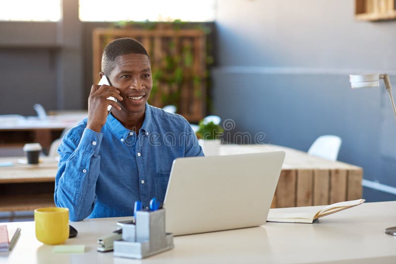 Glimlachende Afrikaanse zakenman hard bij het werk in een modern bureau stock afbeelding Glimlachende Afrikaanse zakenman hard bij het werk in een modern bureau stock afbeelding