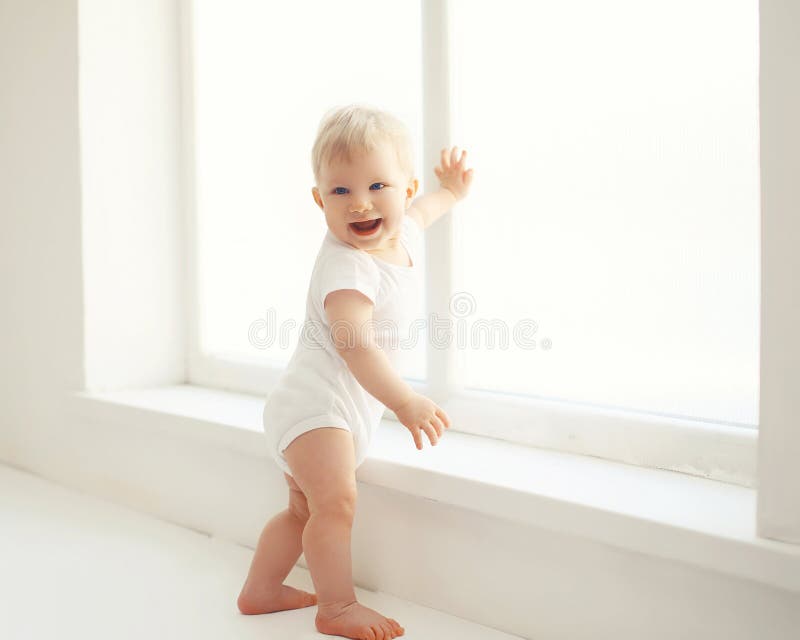 Glimlachende baby die in witte ruimte zich thuis bevinden royalty-vrije stock afbeelding Glimlachende baby die in witte ruimte zich thuis bevinden royalty-vrije stock afbeelding