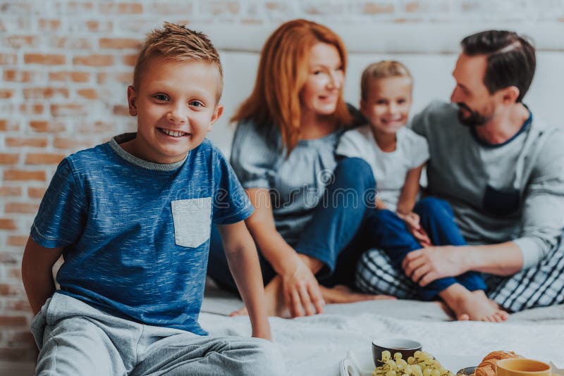 Glimlachende familie die ontbijt samen in ochtend hebben royalty-vrije stock fotografie Glimlachende familie die ontbijt samen in ochtend hebben royalty-vrije stock fotografie