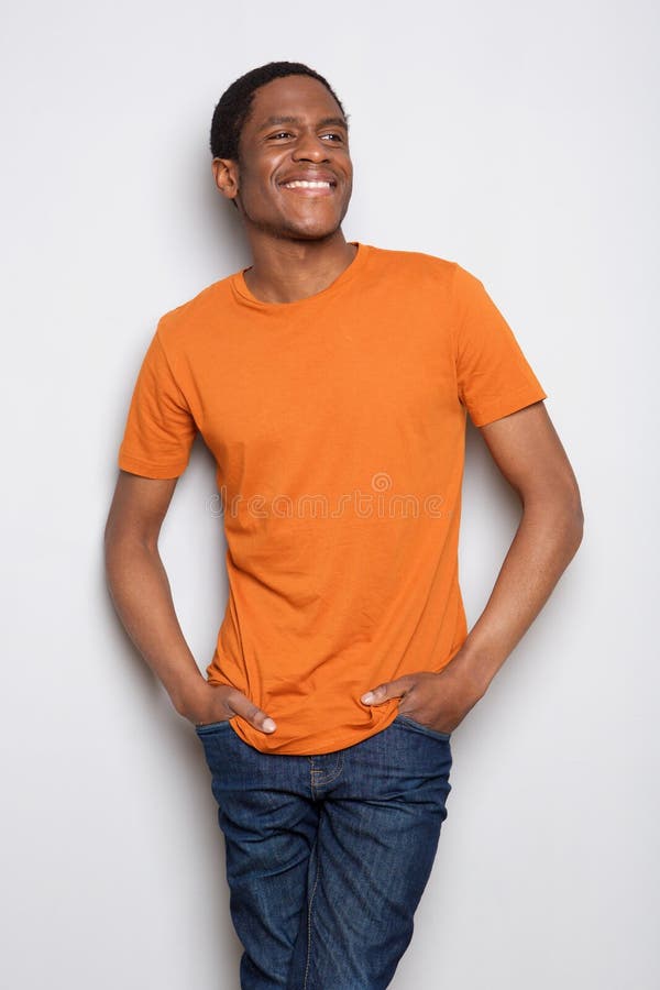 Glimlachende jonge Afrikaanse Amerikaanse mens die zich tegen witte achtergrond bevinden royalty-vrije stock afbeelding Glimlachende jonge Afrikaanse Amerikaanse mens die zich tegen witte achtergrond bevinden royalty-vrije stock afbeelding