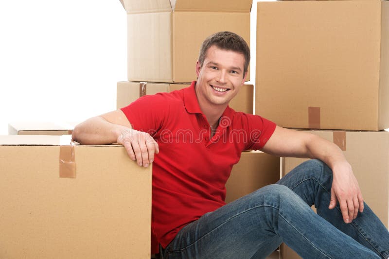 Glimlachende jonge mens met kartondoos stock fotografie Glimlachende jonge mens met kartondoos stock fotografie