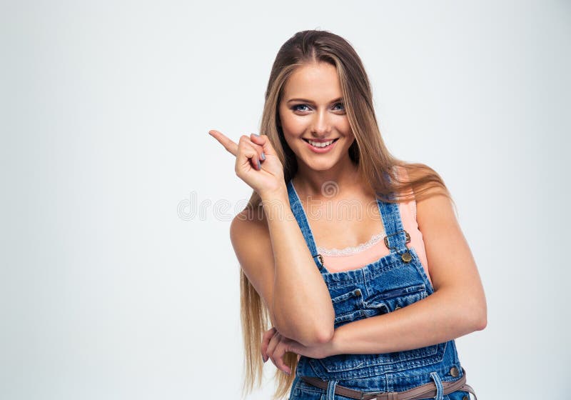 Portrait of a smiling young woman pointing finger away isolated on a white background. Looking at camera. Portrait of a smiling young woman pointing finger away isolated on a white background. Looking at camera