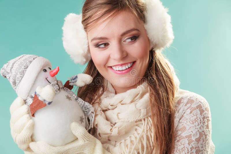 Glimlachende leuke vrouw met weinig sneeuwman De winter stock afbeelding Glimlachende leuke vrouw met weinig sneeuwman De winter stock afbeelding