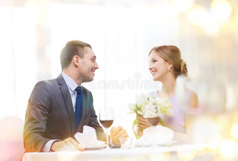 Glimlachende mens die bloemboeket geven bij restaurant royalty-vrije stock fotografie Glimlachende mens die bloemboeket geven bij restaurant royalty-vrije stock fotografie