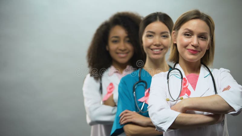 Glimlachende multiraciale verpleegsters met roze linten, het internationale teken van borstkanker stock video Glimlachende multiraciale verpleegsters met roze linten, het internationale teken van borstkanker stock video