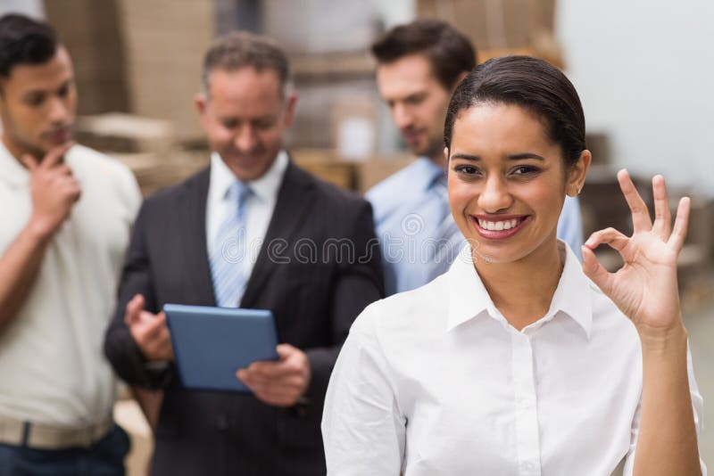Glimlachende pakhuismanager die o.k. gebaar maken royalty-vrije stock afbeelding Glimlachende pakhuismanager die o.k. gebaar maken royalty-vrije stock afbeelding