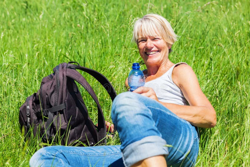Glimlachende vrouw bij een wandelingsrust royalty-vrije stock fotografie Glimlachende vrouw bij een wandelingsrust royalty-vrije stock fotografie