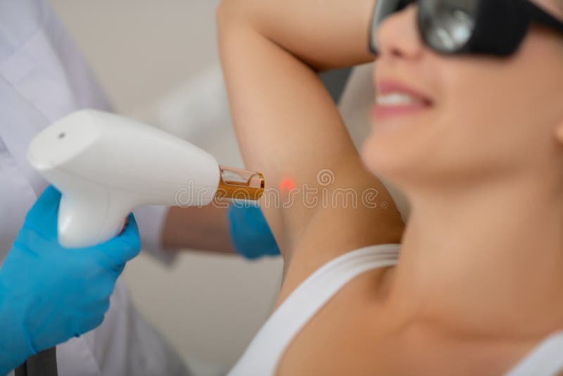 Glimlachende vrouw die de huidbehandeling krijgt van de laseroksel royalty-vrije stock afbeeldingen Glimlachende vrouw die de huidbehandeling krijgt van de laseroksel royalty-vrije stock afbeeldingen