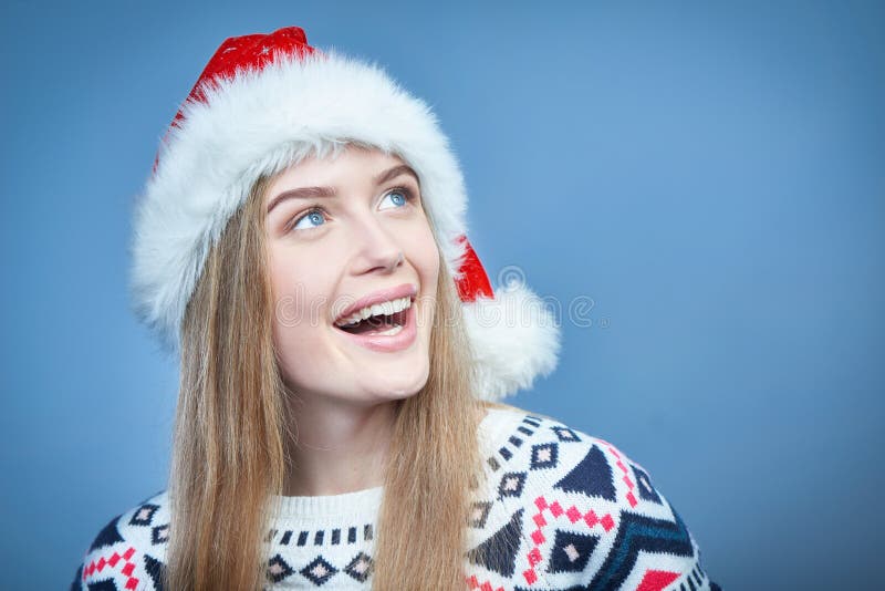 Glimlachende vrouw die Kerstmanhoed dragen die weg exemplaarruimte bekijken royalty-vrije stock afbeelding Glimlachende vrouw die Kerstmanhoed dragen die weg exemplaarruimte bekijken royalty-vrije stock afbeelding