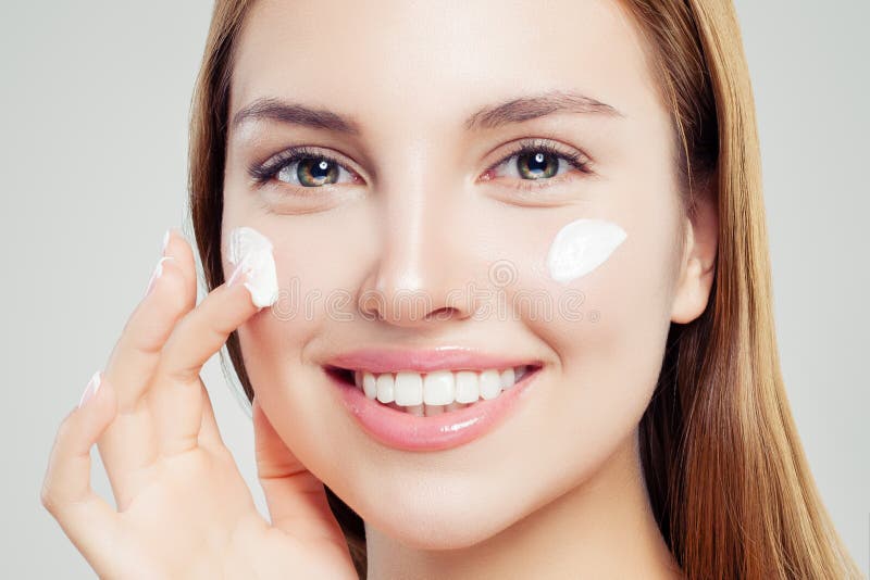 Glimlachende vrouw die met duidelijke huid bevochtigende room, mooie vrouwelijke gezichtsclose-up toepassen Skincare, schoonheid stock afbeeldingen Glimlachende vrouw die met duidelijke huid bevochtigende room, mooie vrouwelijke gezichtsclose-up toepassen Skincare, schoonheid stock afbeeldingen