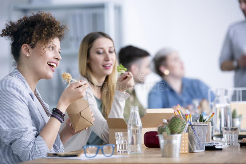 Glimlachende werknemers die lunch eten stock afbeelding Glimlachende werknemers die lunch eten stock afbeelding