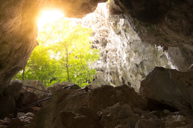A glimmer of hope as rays of light stream into the cave from the underground perspective looking upward toward the sun in this concept photo.
