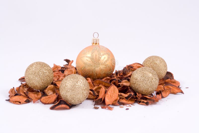 Gold and glittery Christmas ornaments arranged on bed of dry leaves. Gold and glittery Christmas ornaments arranged on bed of dry leaves