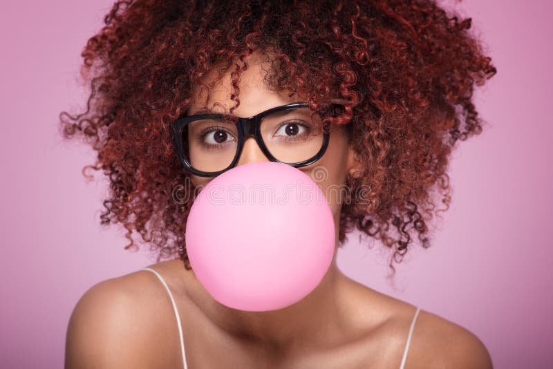 Globo del chicle de la muchacha del Afro que sopla fotografía de archivo libre de regalías Globo del chicle de la muchacha del Afro que sopla fotografía de archivo libre de regalías