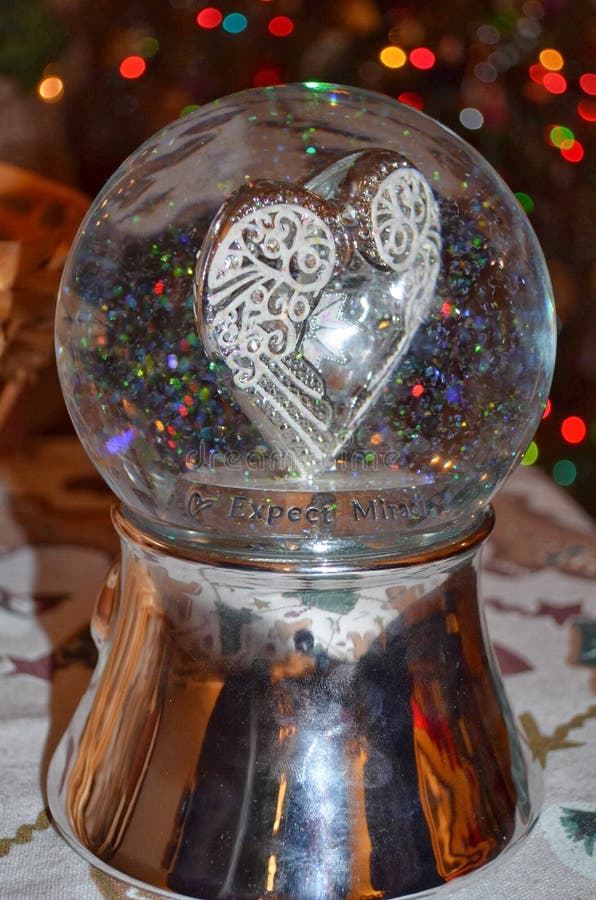 Globo di neve a forma di cuore scintillante immagine stock libera da diritti