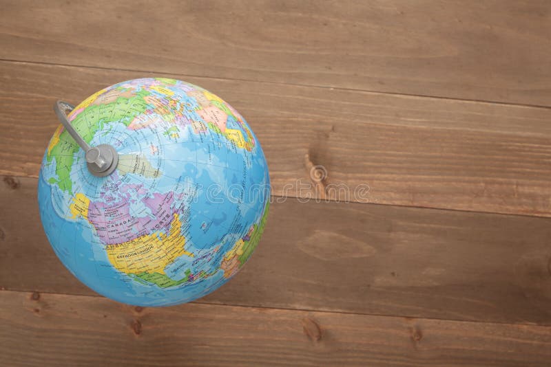 Elche, Spain. March 31, 2016: Globe and a camera on wooden background. Elche, Spain. March 31, 2016: Globe and a camera on wooden background