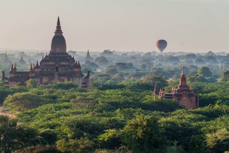 Globo sobre globos aerostáticos de bagan flotando entre el horizonte de los templos de myanmar