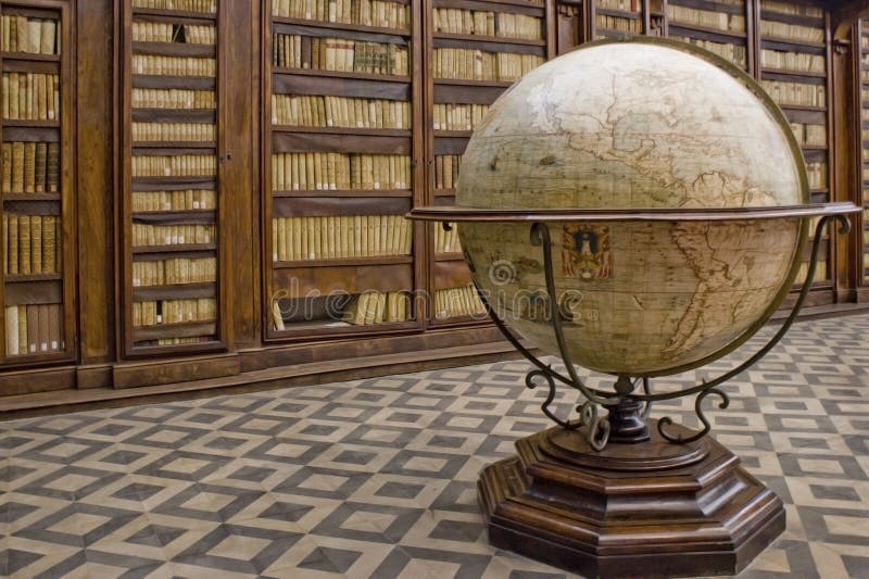 A globe of the earth sits in front of a collection of rare old books. A globe of the earth sits in front of a collection of rare old books.