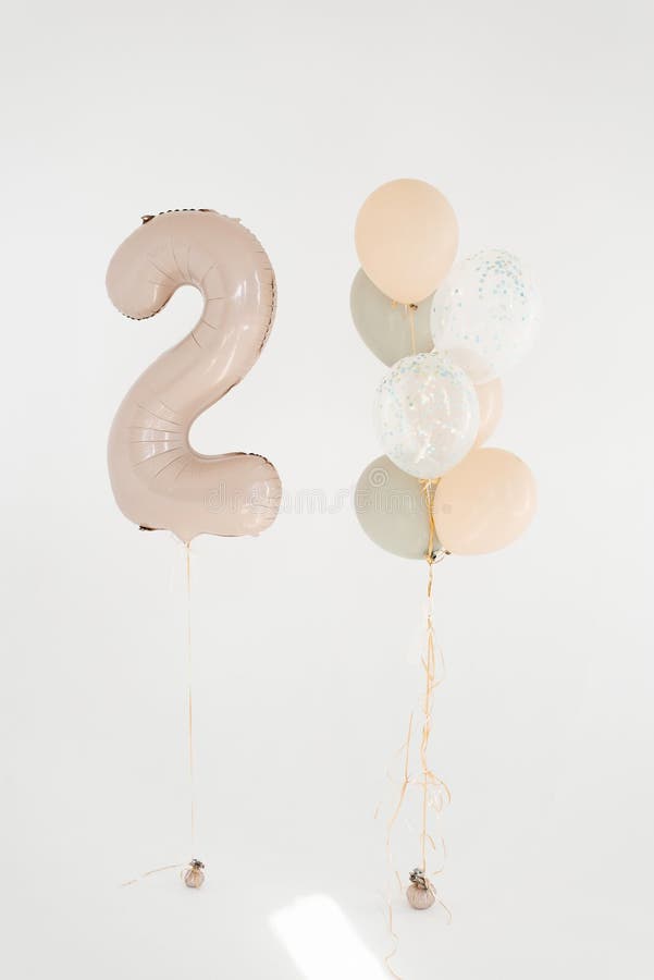 Globos de cumpleaños festivos uno de los cuales tiene el puesto número dos al lado del otro fotografía de archivo