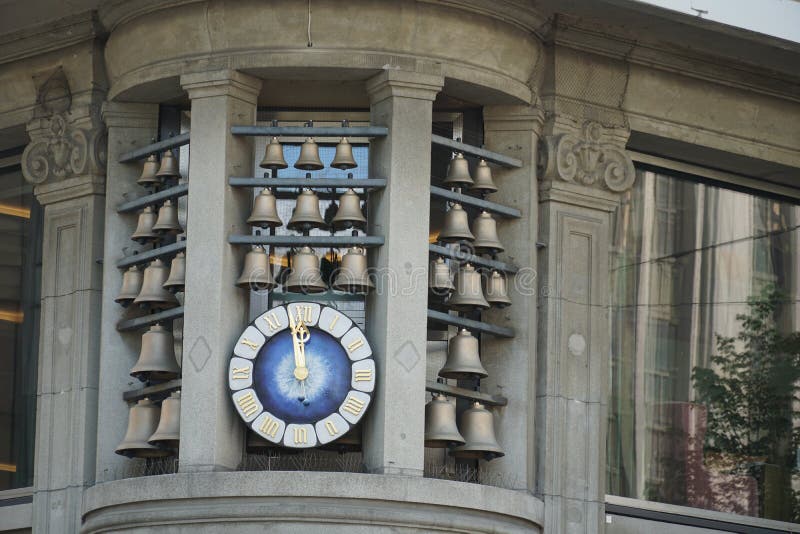 Glockenspiel, Bahnhofstrasse Zurich, bells of various sizes placed around a clock on the corner of a historical building close up.