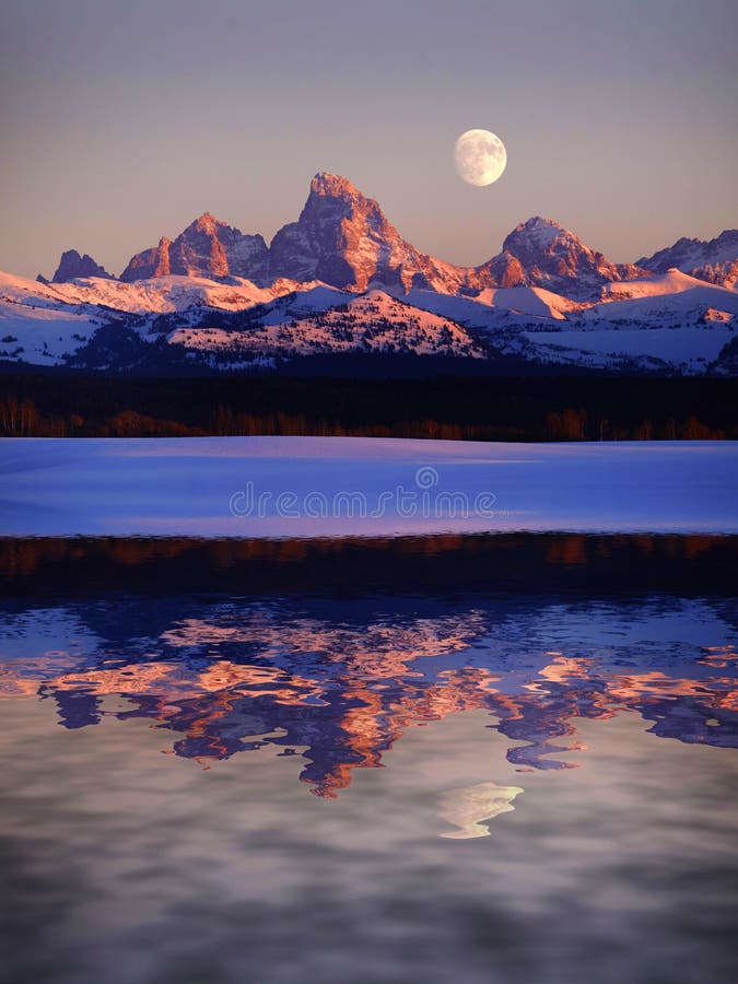 Gloed die van zonsondergang wijst de Lichte Alpen op de Bergen van Tetons Teton met Maan de vijver op meer van het bezinningswate stock foto Gloed die van zonsondergang wijst de Lichte Alpen op de Bergen van Tetons Teton met Maan de vijver op meer van het bezinningswate stock foto