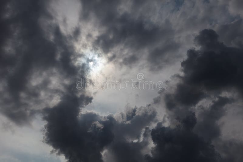 Gloomy, dramatic sky, the sun shines through the black clouds stock images
