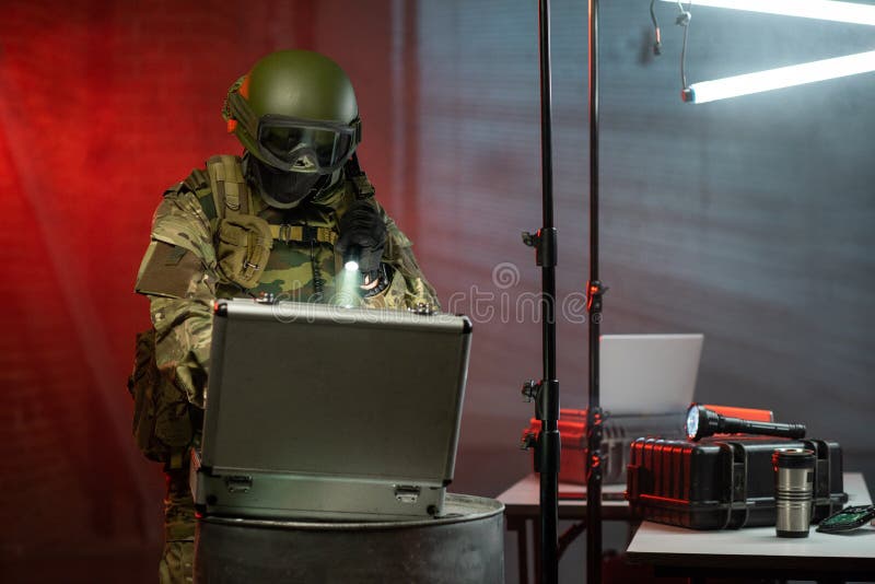 Gloved criminal in camouflage attire committing cyber crime stock photography