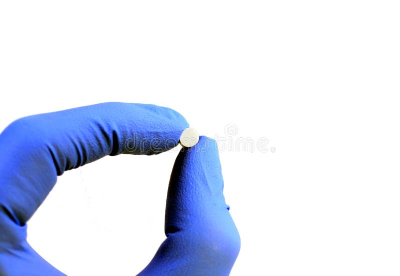 Gloved hand holding a pill