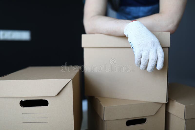 Gloved hands loader lie on cardboard boxes office royalty free stock photo