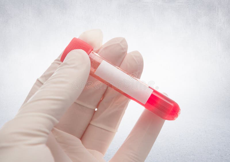 Gloved рука с красным контейнером против белой стены стоковые фотографии rf Gloved рука с красным контейнером против белой стены стоковые фотографии rf