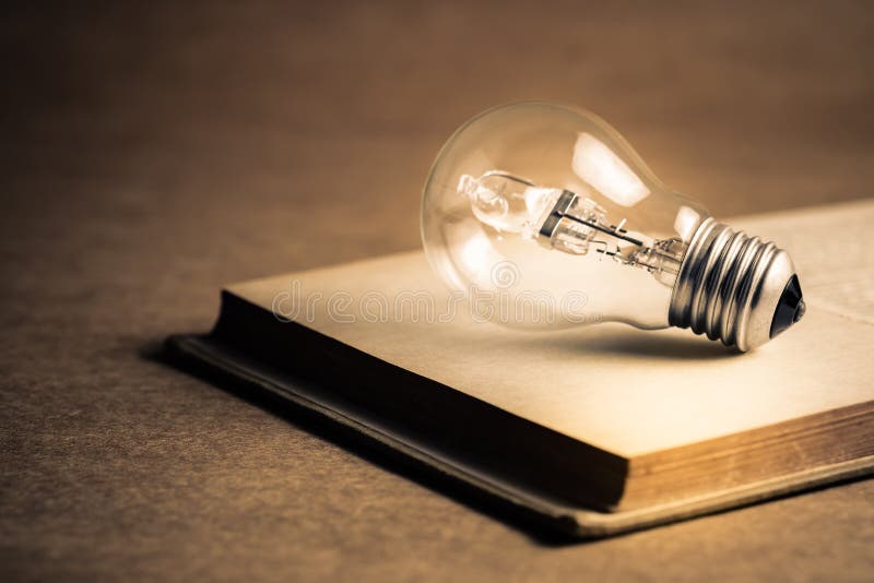 Glowing Bulb and Old Books stock image. Image of concept 148971415