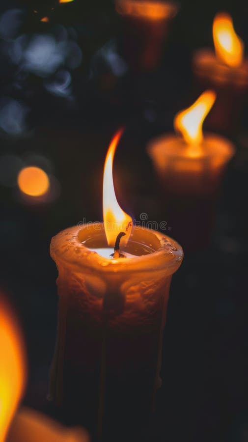 Glowing candle in the dark with soft focus background stock images