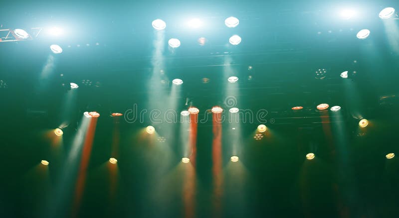 Glowing ceiling spotlights lights the stage during concert foto de stock